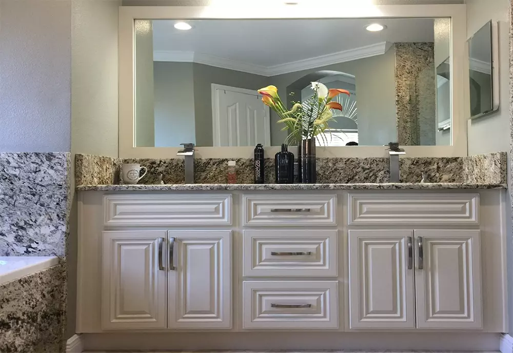 Shaker bathroom vanity with a stone top and framed mirror